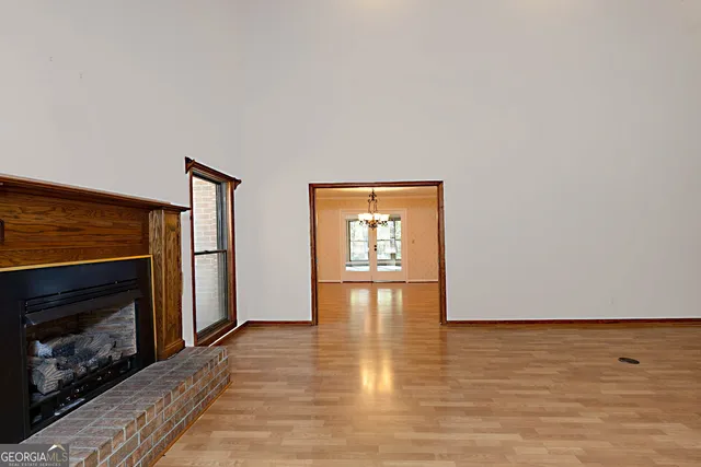 a view of empty room with wooden floor and fireplace