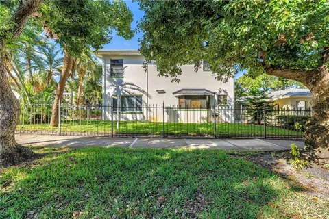 a view of a house with a big yard plants and large trees