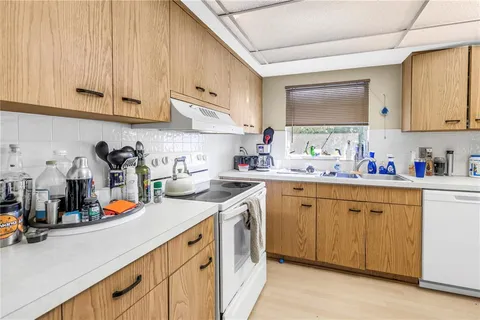 a kitchen with white cabinets and white appliances