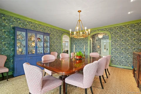 a view of a dining room with furniture a chandelier and wooden floor