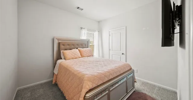 a bed sitting in a bedroom next to a window