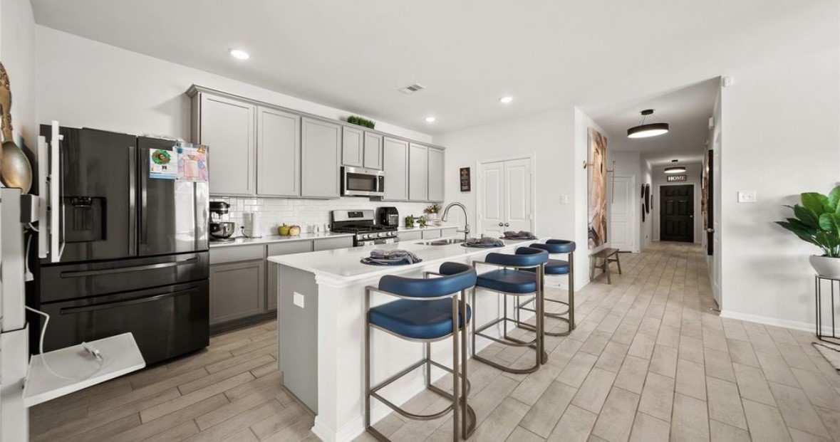 1326 Ponderosa Pne Drive Rosharon, TX 77583 - Photo 3 of 14 a kitchen with a refrigerator a stove a sink and a dining table with wooden floor