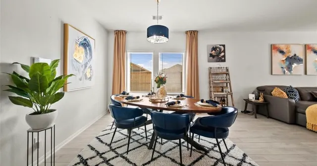 a dining room with furniture and a large window