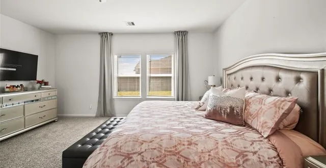 a bedroom with a bed and flat screen tv