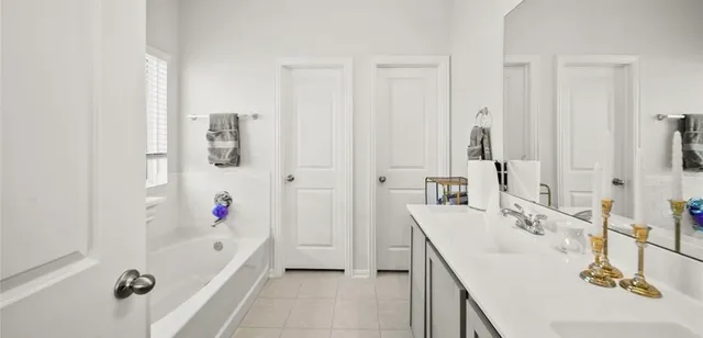 a bathroom with a tub sink and mirror