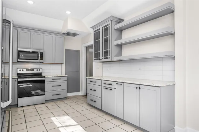a kitchen with stainless steel appliances granite countertop a refrigerator sink and stove