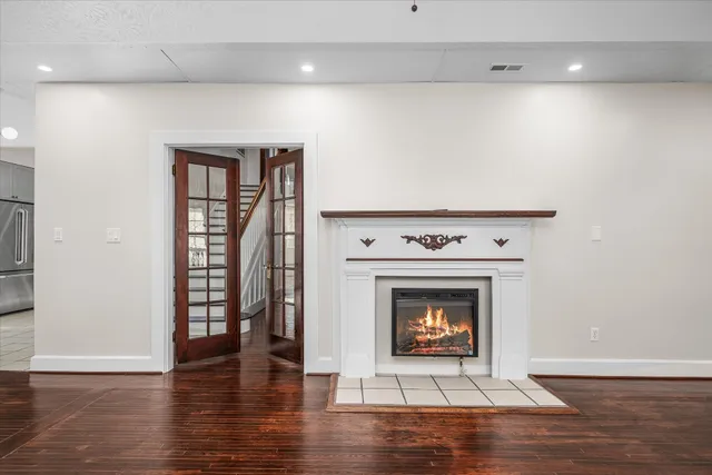 a view of a refrigerator in kitchen and an empty room