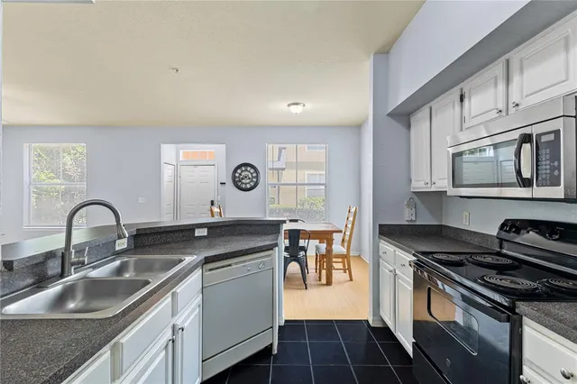a kitchen with granite countertop a sink stainless steel appliances and cabinets