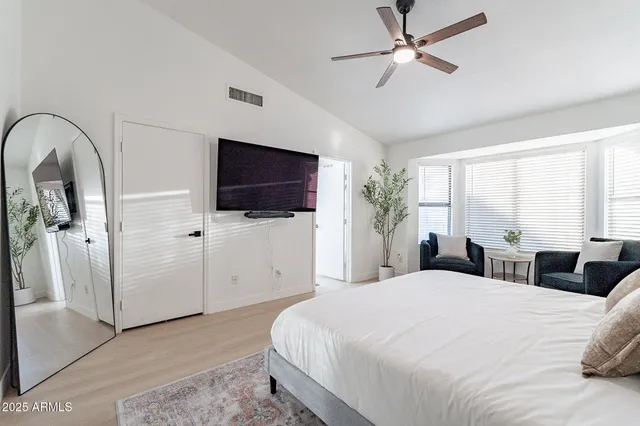 a bedroom with a large bed and ceiling fan