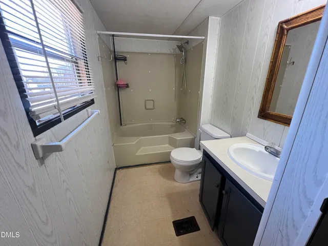 a bathroom with a sink a toilet a mirror and shower