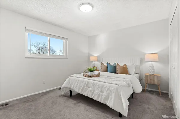 a bedroom with a bed and painting on the wall