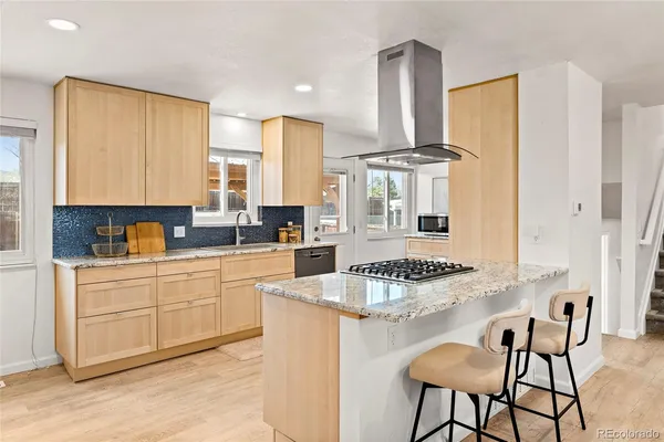 a kitchen with granite countertop a sink stove and refrigerator