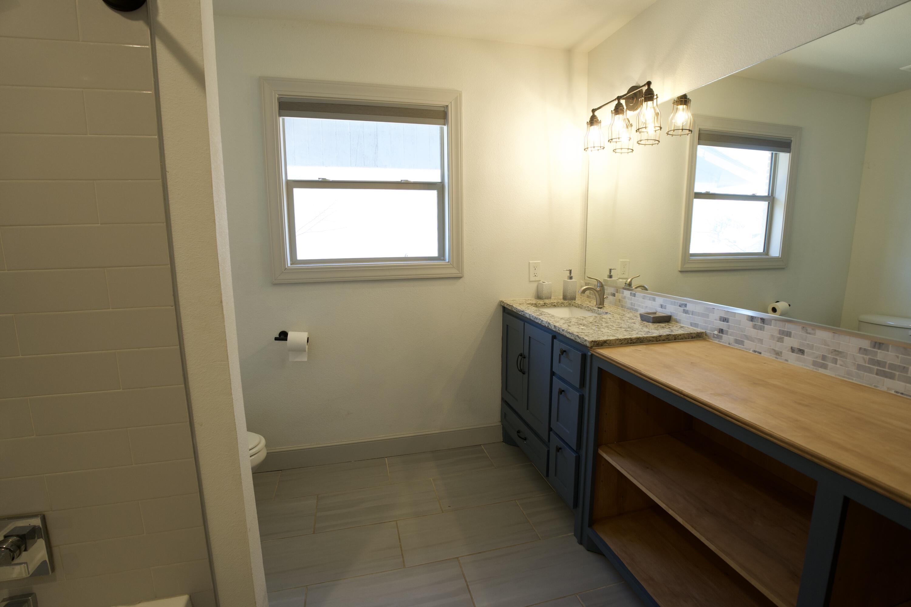 2517 52nd Street Lubbock, TX 79413 - Photo 15 of 17 a bathroom with a sink a vanity and a mirror