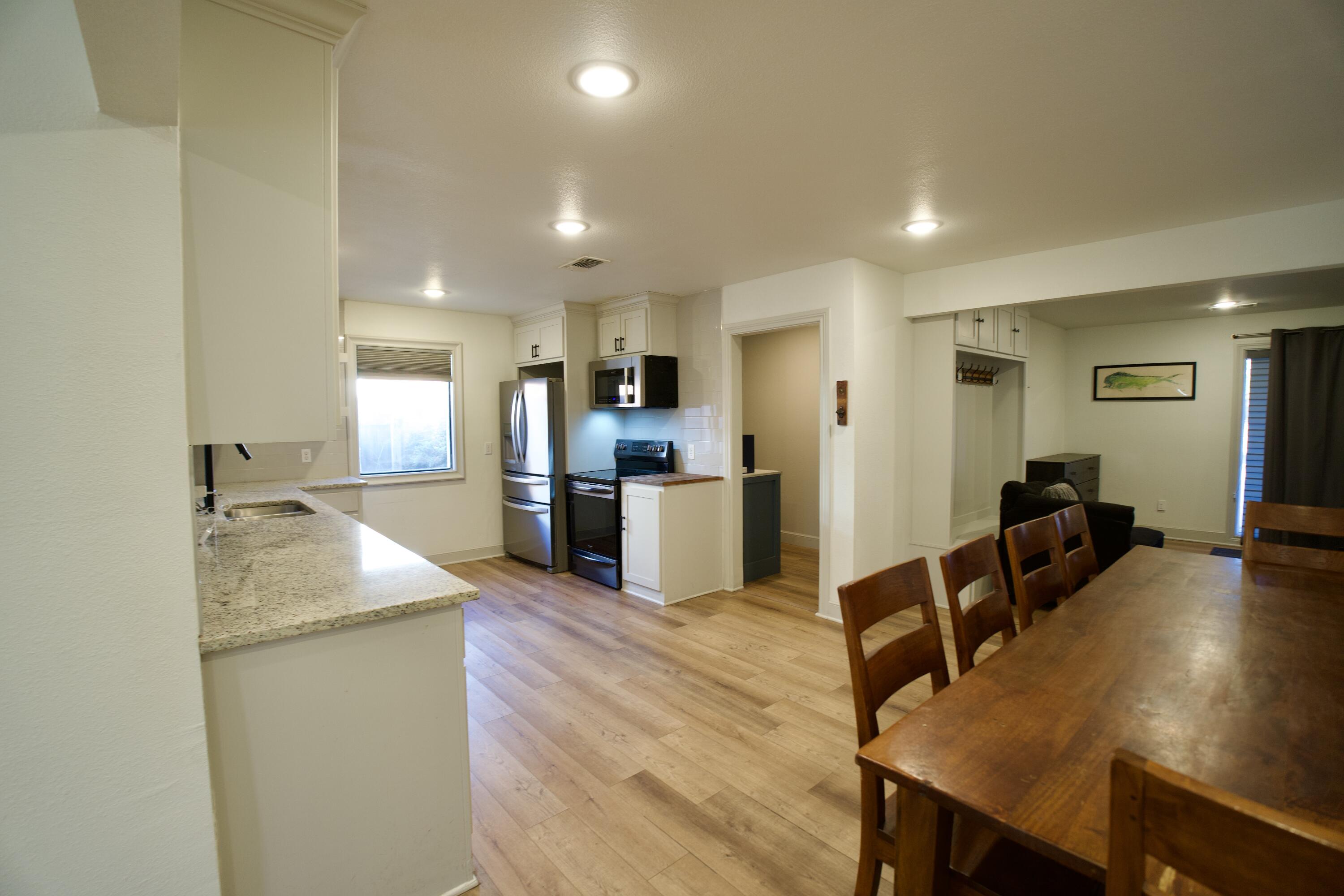 2517 52nd Street Lubbock, TX 79413 - Photo 6 of 17 a kitchen with kitchen island a stove a table and chairs in it