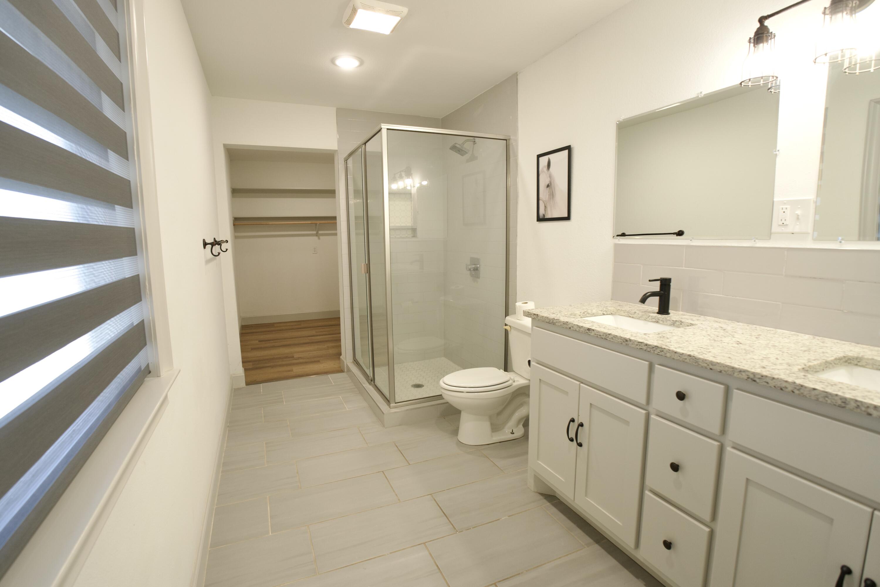 2517 52nd Street Lubbock, TX 79413 - Photo 10 of 17 a spacious bathroom with a granite countertop sink toilet and shower