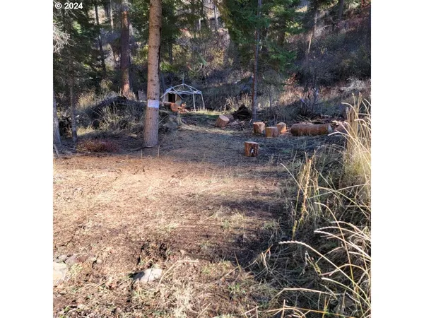 a backyard of a house with table and chairs under an umbrella