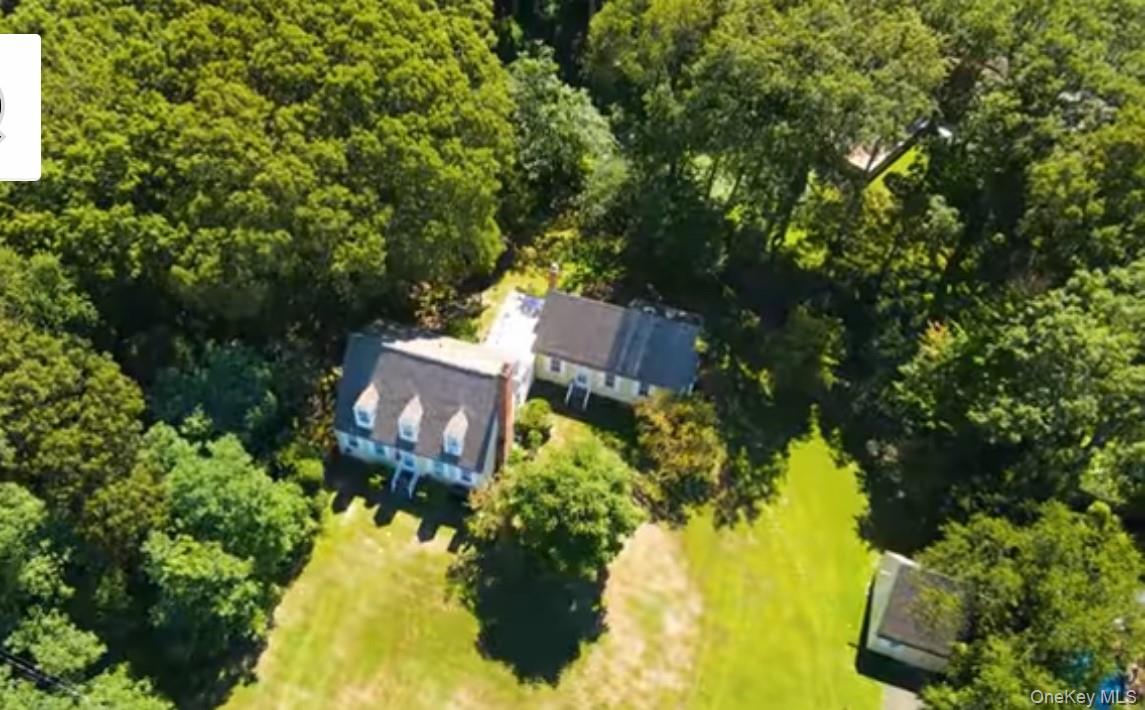 an aerial view of a house with swimming pool and garden