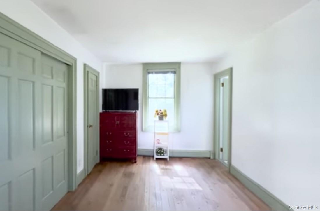 24 Hawkins Road Stony Brook, NY 11790 - Photo 15 of 45 a view of a livingroom with wooden floor a flat screen tv and staircase