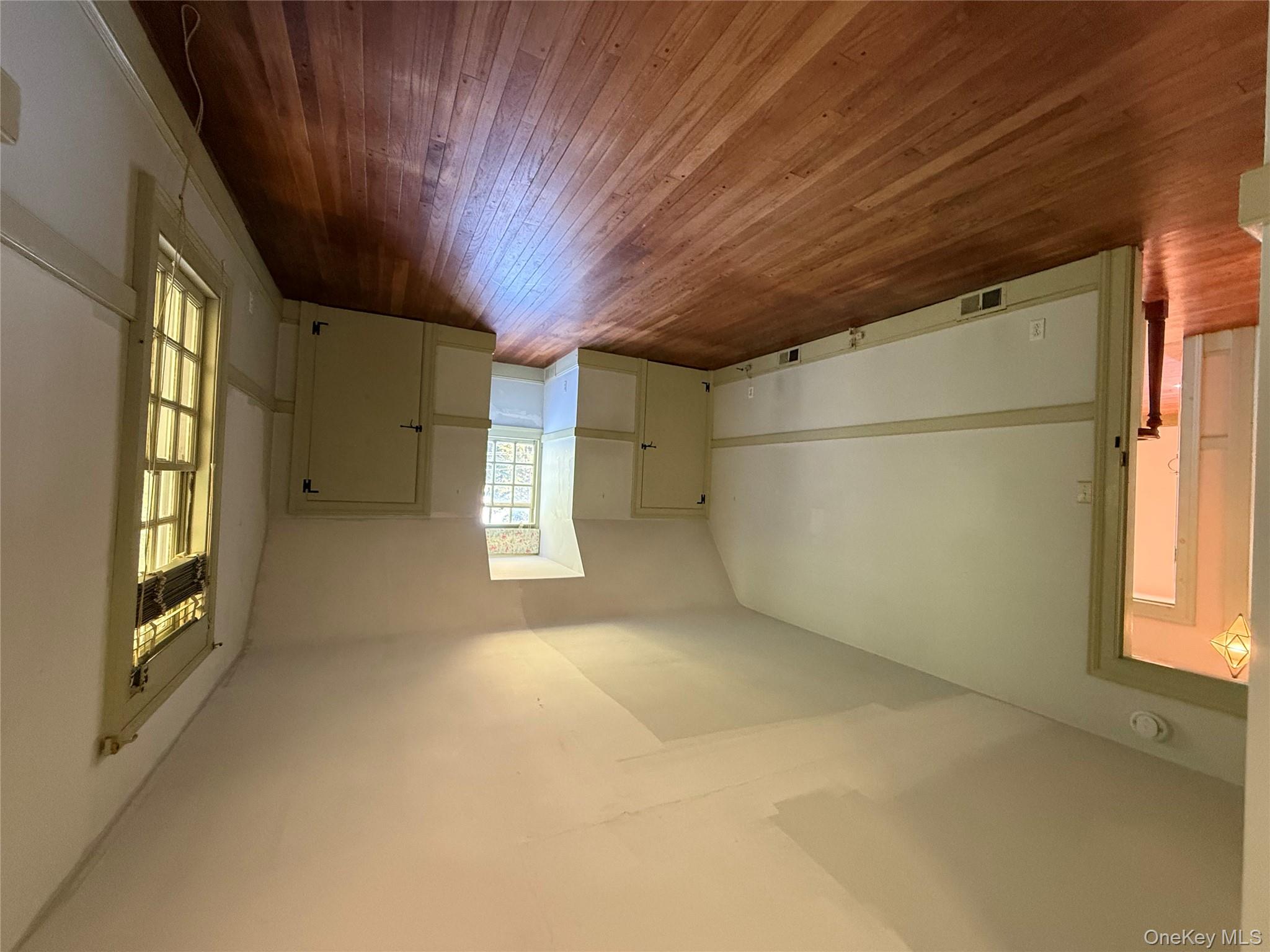 24 Hawkins Road Stony Brook, NY 11790 - Photo 27 of 45 an empty room with wooden floor and windows