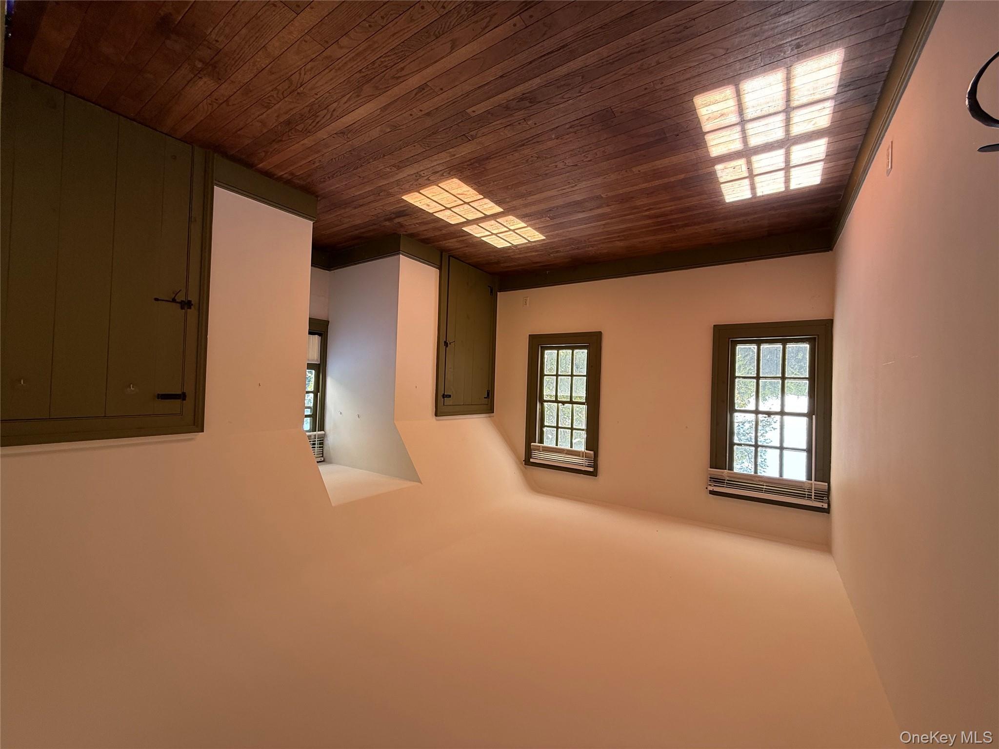 24 Hawkins Road Stony Brook, NY 11790 - Photo 28 of 45 an empty room with wooden floor and windows