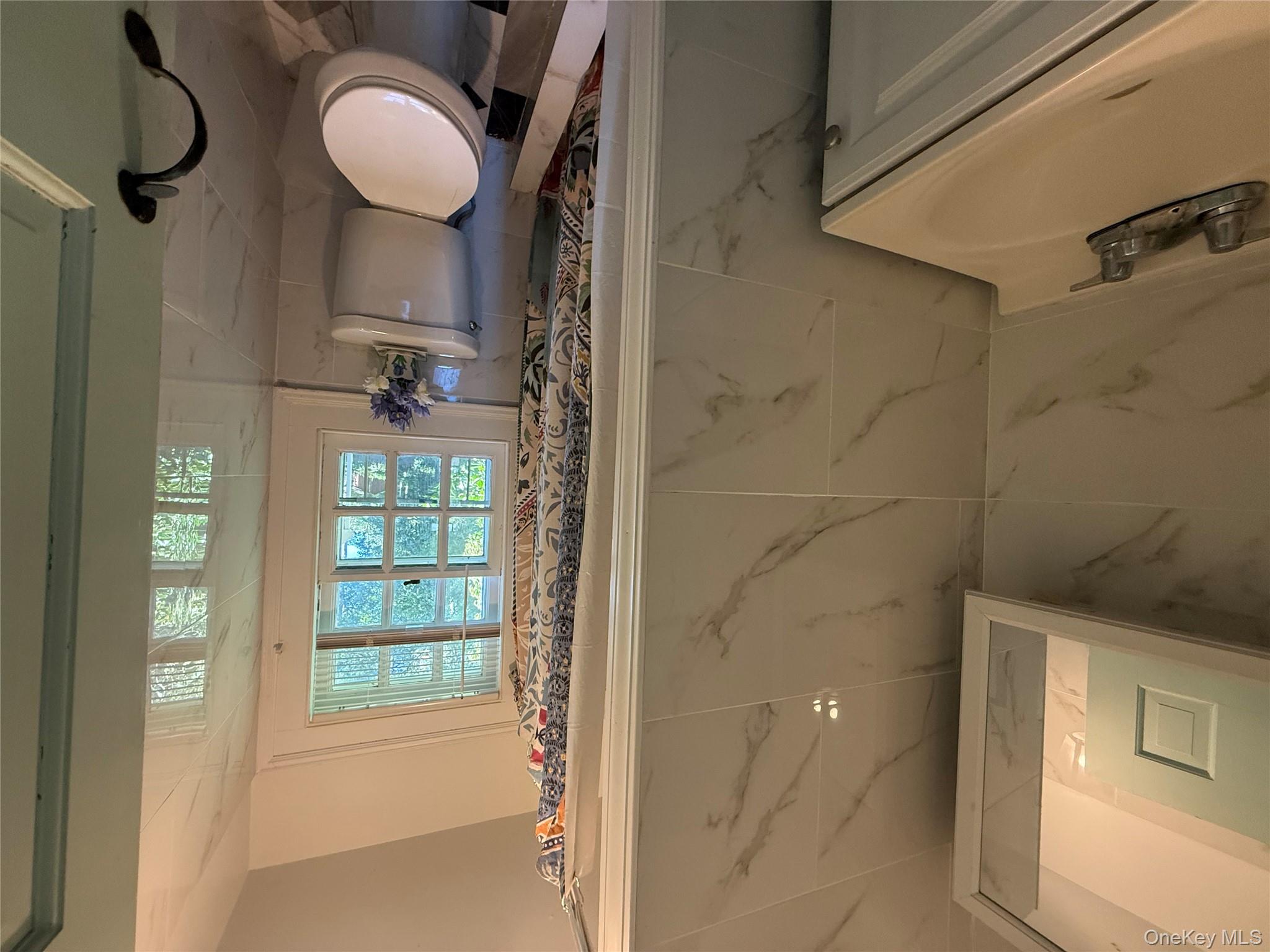 24 Hawkins Road Stony Brook, NY 11790 - Photo 30 of 45 a bathroom with a toilet a sink and a window