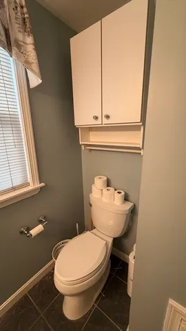 a bathroom with a toilet a sink and a window