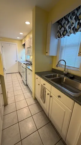 a kitchen with a sink a stove and cabinets