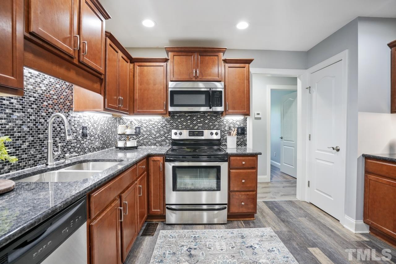 47 Hadleigh Way Fuquay-Varina, NC 27526 - Photo 12 of 37 a kitchen with stainless steel appliances granite countertop a stove a sink and a microwave