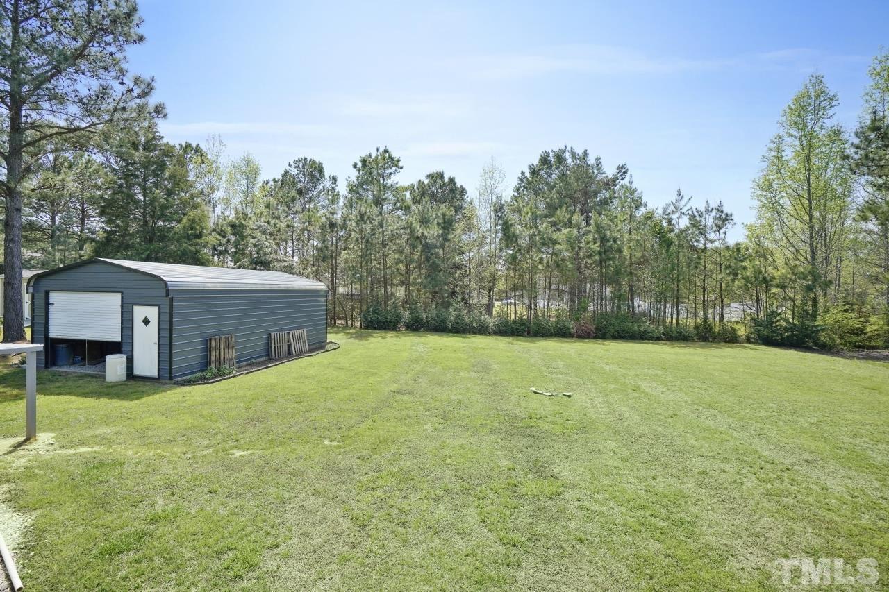 47 Hadleigh Way Fuquay-Varina, NC 27526 - Photo 31 of 37 a backyard of a house with large trees and a barn
