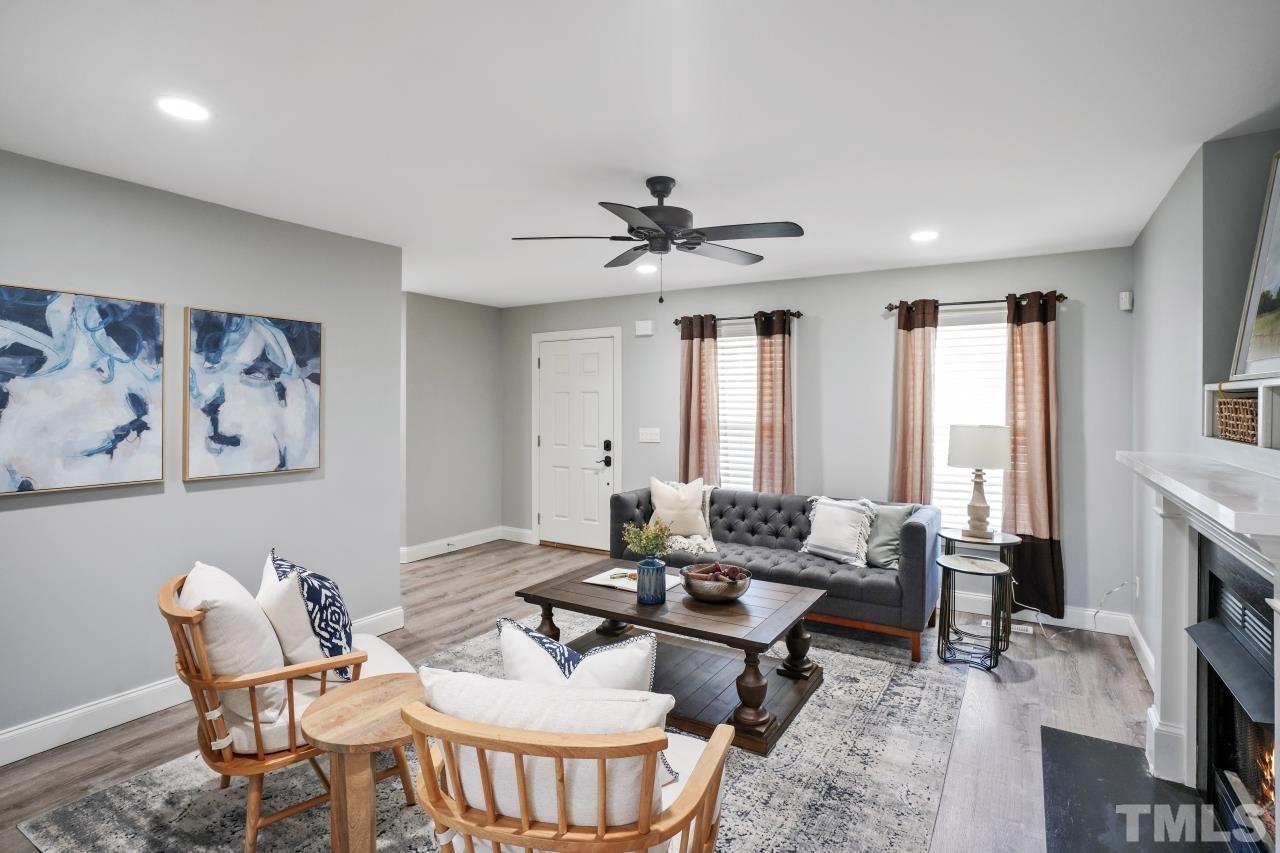 47 Hadleigh Way Fuquay-Varina, NC 27526 - Photo 5 of 37 a living room with furniture a fireplace and a flat screen tv