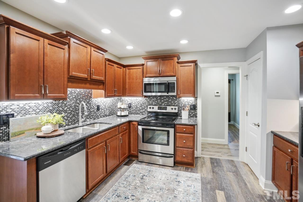 47 Hadleigh Way Fuquay-Varina, NC 27526 - Photo 10 of 37 a kitchen with stainless steel appliances granite countertop a stove a sink and a refrigerator