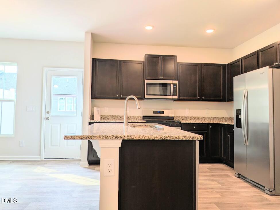 4029 Kidd Place Durham, NC 27703 - Photo 12 of 28 a kitchen with stainless steel appliances a sink and a refrigerator