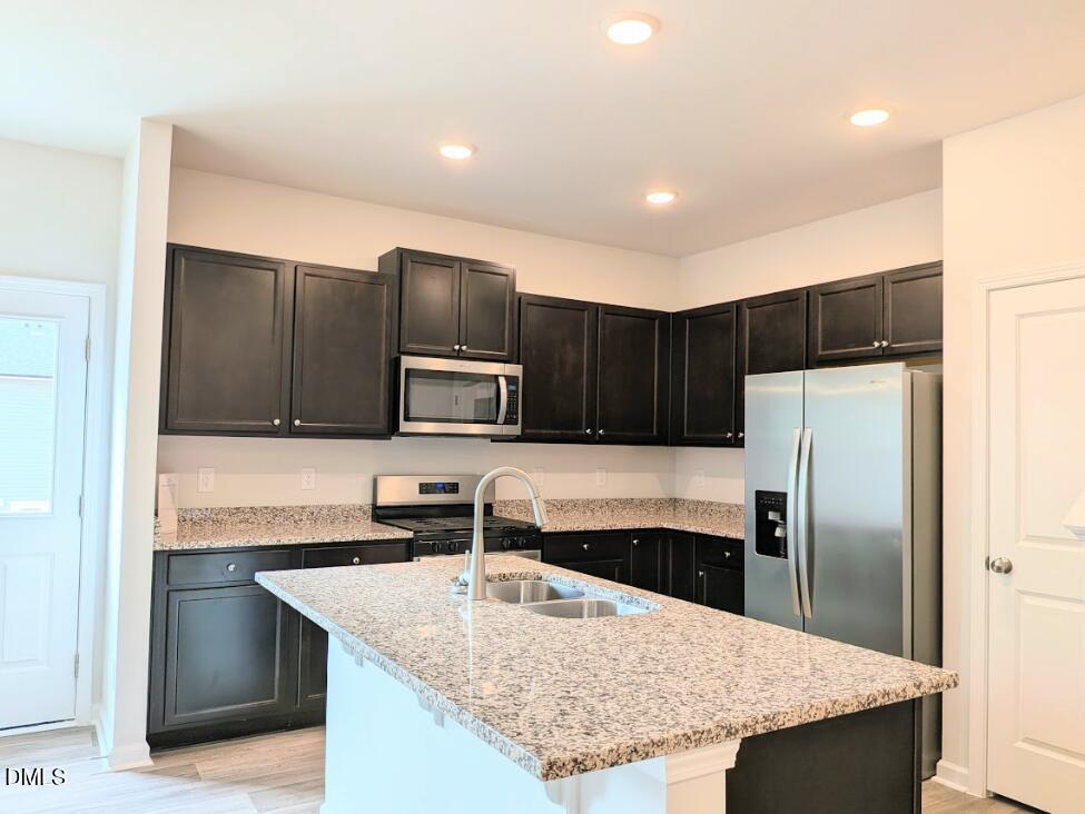4029 Kidd Place Durham, NC 27703 - Photo 13 of 28 a kitchen with kitchen island a sink refrigerator and microwave