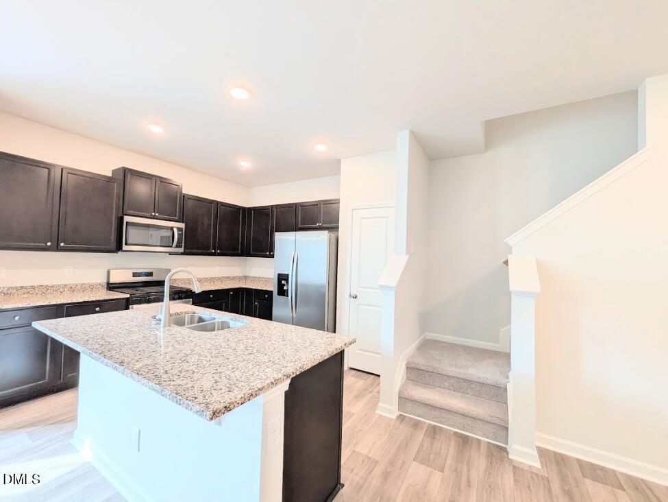4029 Kidd Place Durham, NC 27703 - Photo 14 of 28 a kitchen with stainless steel appliances granite countertop a sink stove and refrigerator