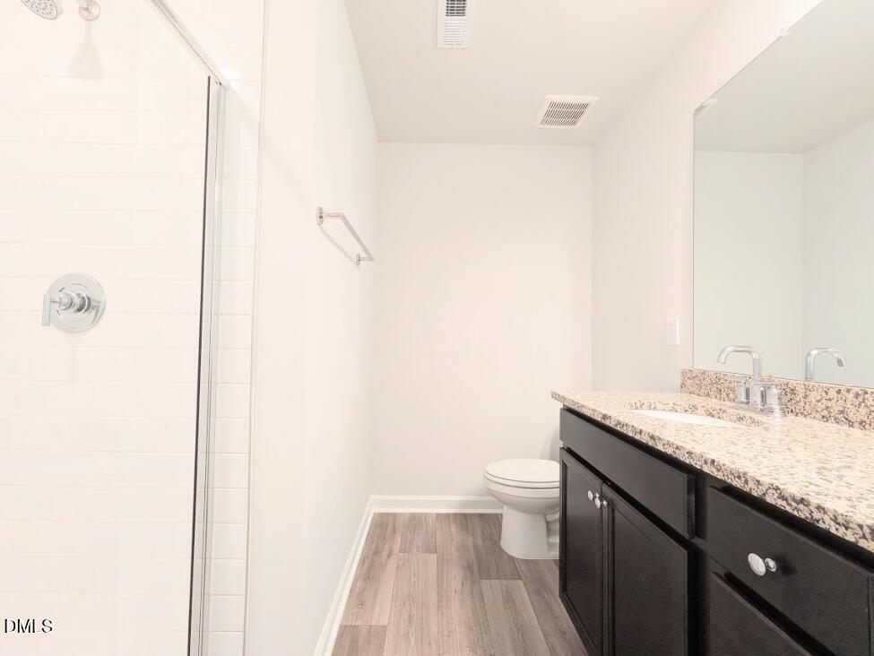 4029 Kidd Place Durham, NC 27703 - Photo 20 of 28 a bathroom with a granite countertop sink a toilet and a mirror