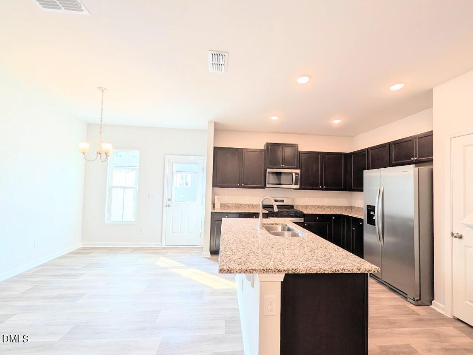4029 Kidd Place Durham, NC 27703 - Photo 10 of 28 a kitchen with granite countertop a refrigerator and a sink