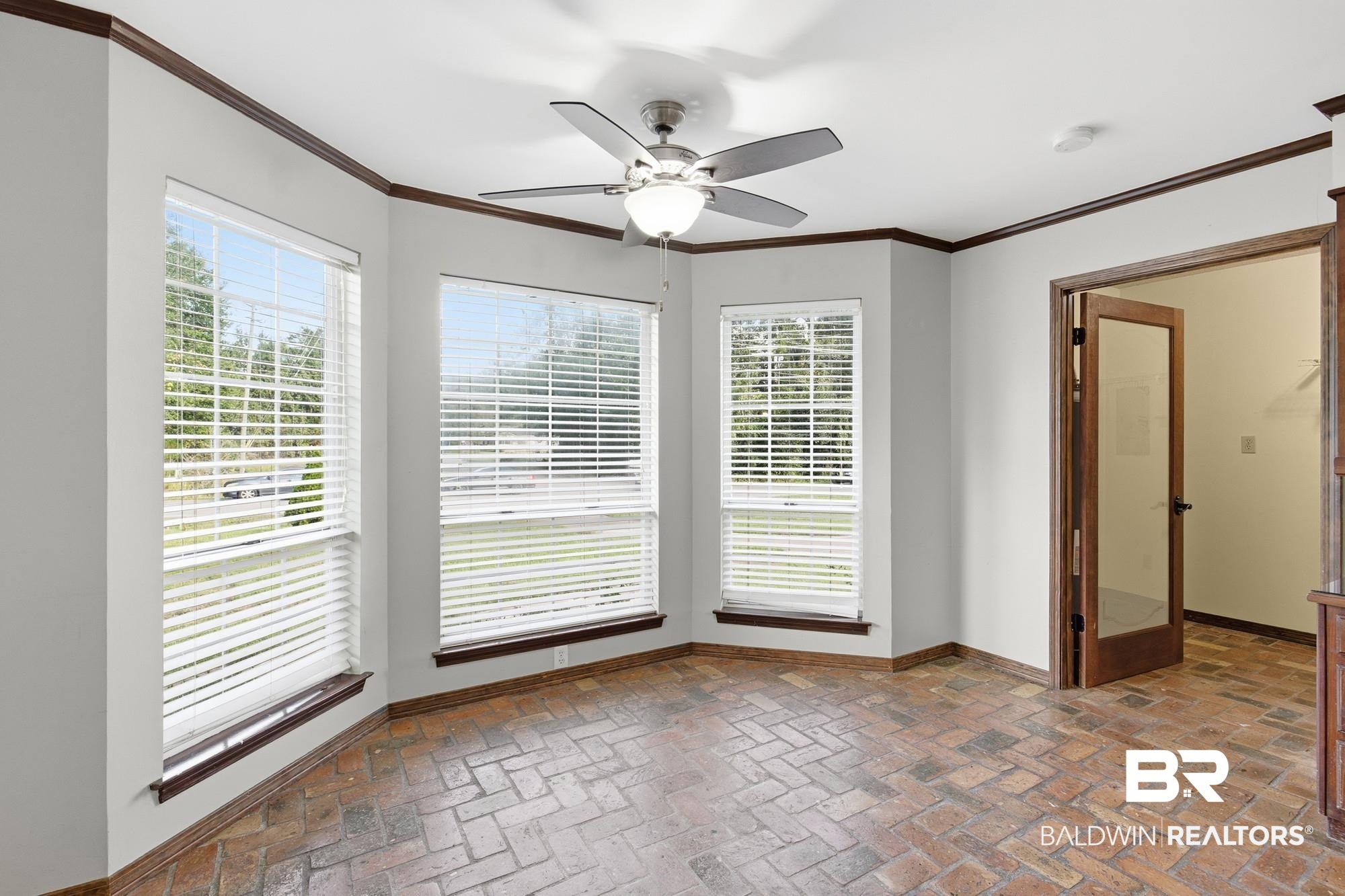 9215 Shiloh Drive Mobile, AL 36695 - Photo 9 of 32 Unfurnished room featuring crown molding, brick flooring, and a ceiling fan