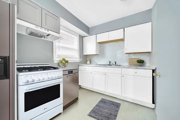a kitchen with granite countertop a stove sink and cabinets