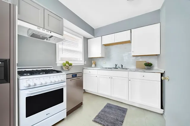 a kitchen with granite countertop a stove sink and cabinets