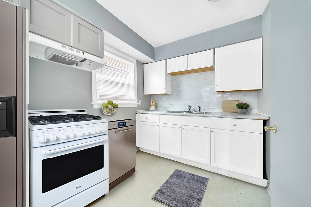 16048 Halsted Street, Unit 2 Harvey, IL 60426 - Photo 3 of 12 a kitchen with granite countertop a stove sink and cabinets