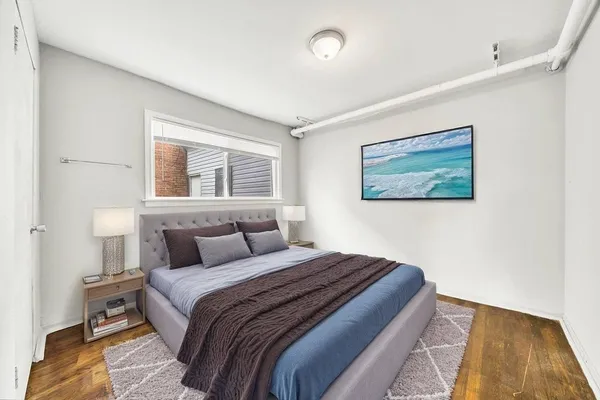 a bedroom with a bed and a painting on the wall