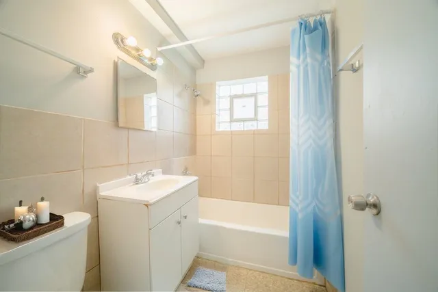 a bathroom with a sink toilet vanity and tub