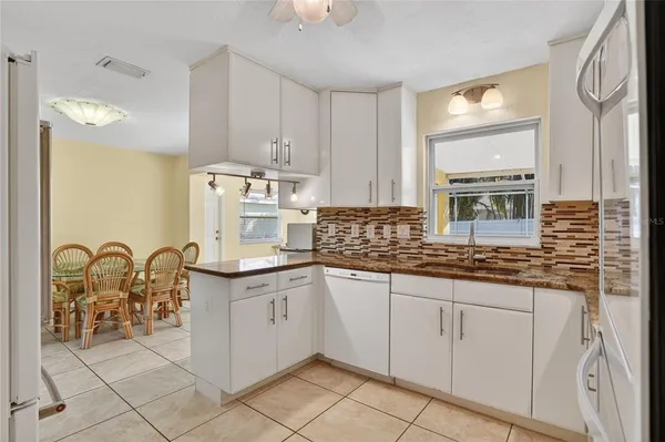 a kitchen with granite countertop white cabinets and appliances