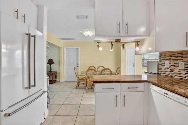 a kitchen with granite countertop a sink and a refrigerator
