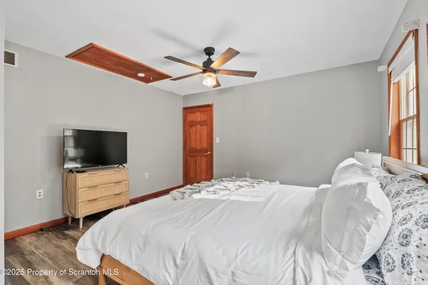 a bedroom with a bed and wooden floor