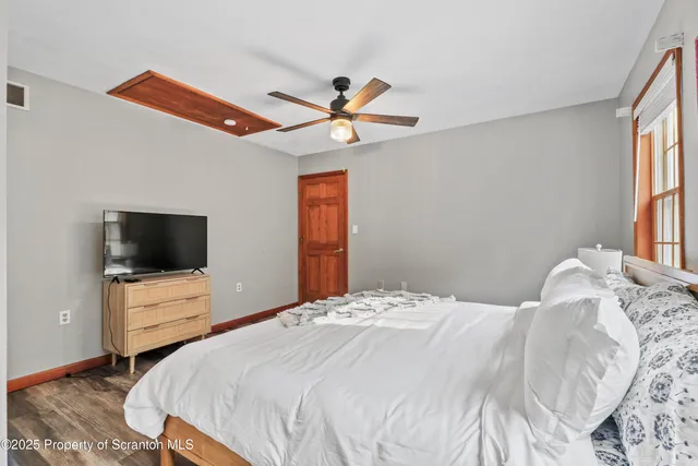 a bedroom with a bed and wooden floor