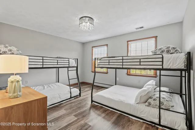 a spacious bedroom with a bed and wooden floor