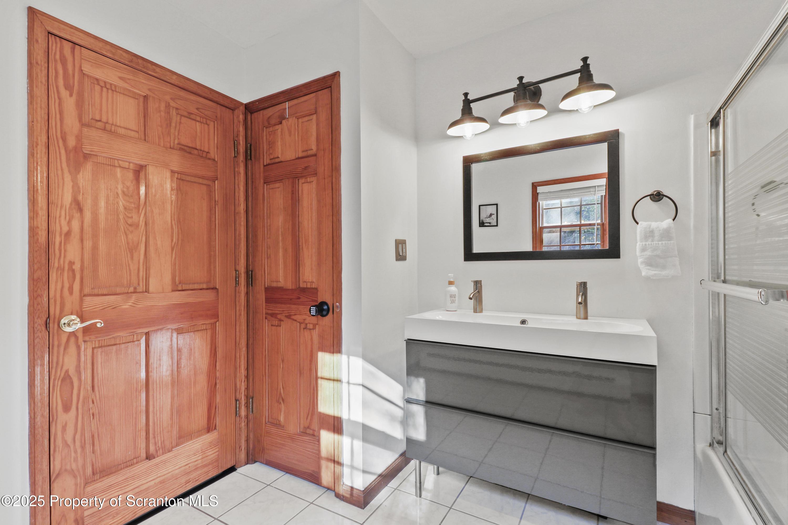 1509 Creek Road New Milford, PA 18834 - Photo 29 of 64 a bathroom with a sink a mirror and a shower