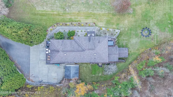 an aerial view of a house with swimming pool and large trees