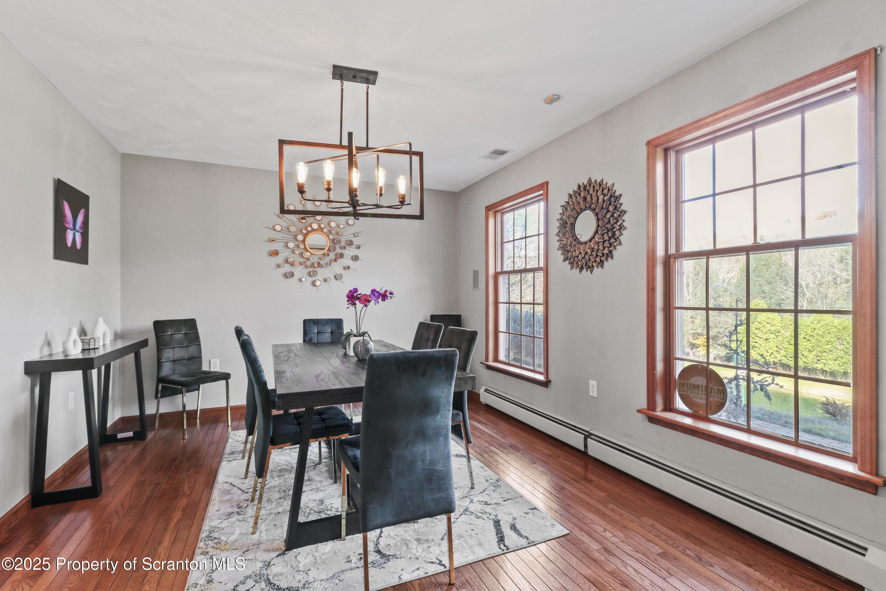 1509 Creek Road New Milford, PA 18834 - Photo 6 of 64 a view of a dining room with furniture a chandelier and wooden floor